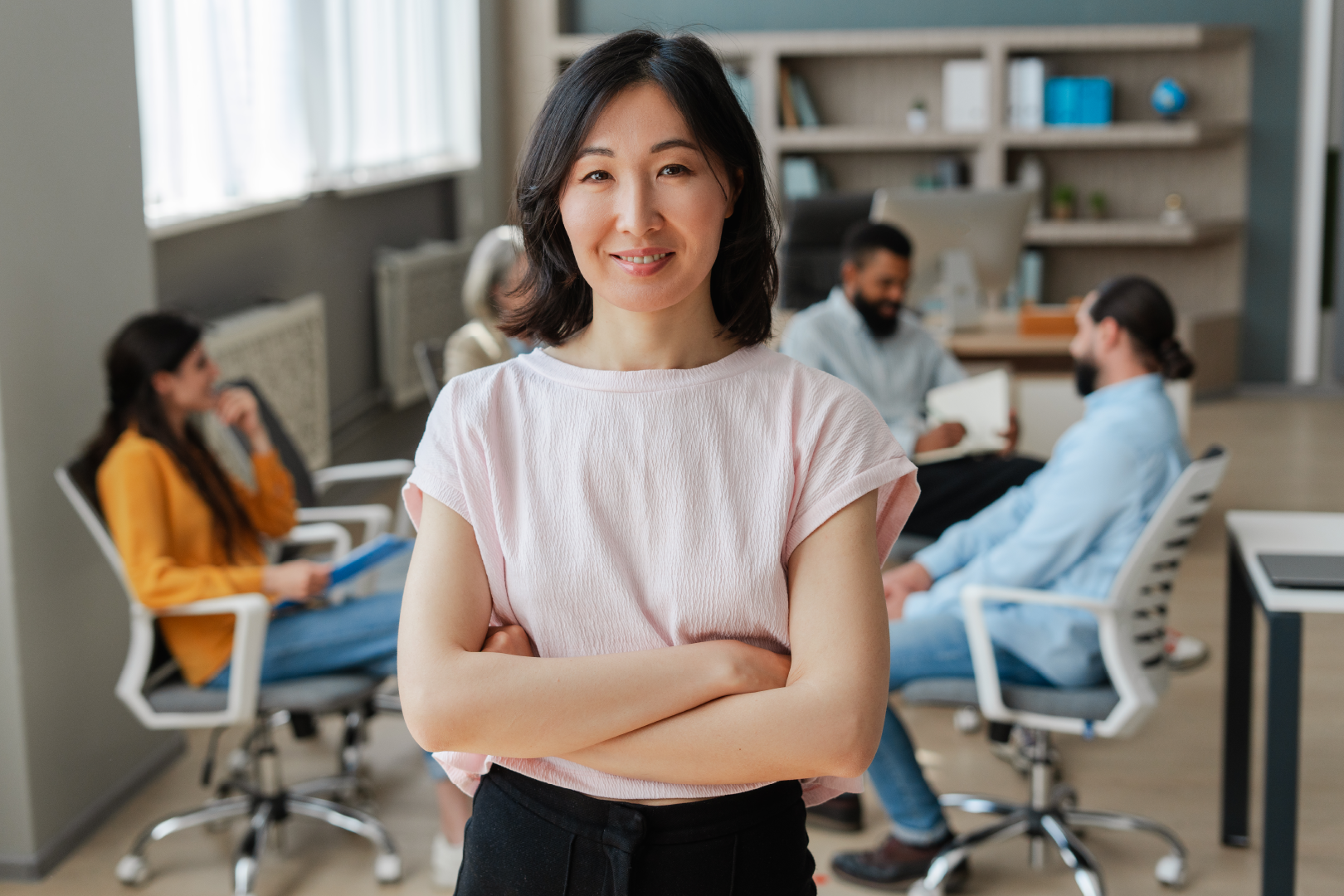 Woman business owner with team sitting behind her at a desk